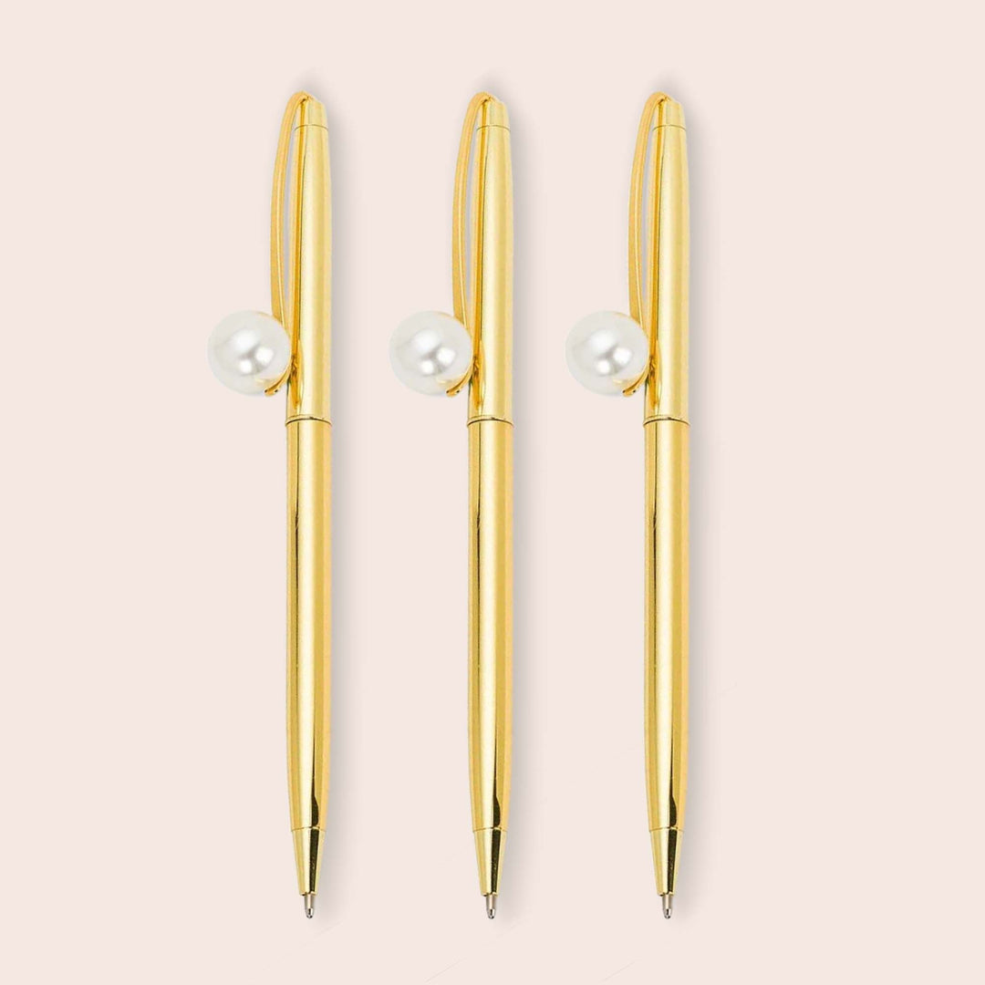 A bundle of 3 golden pens with a pearl at the top 